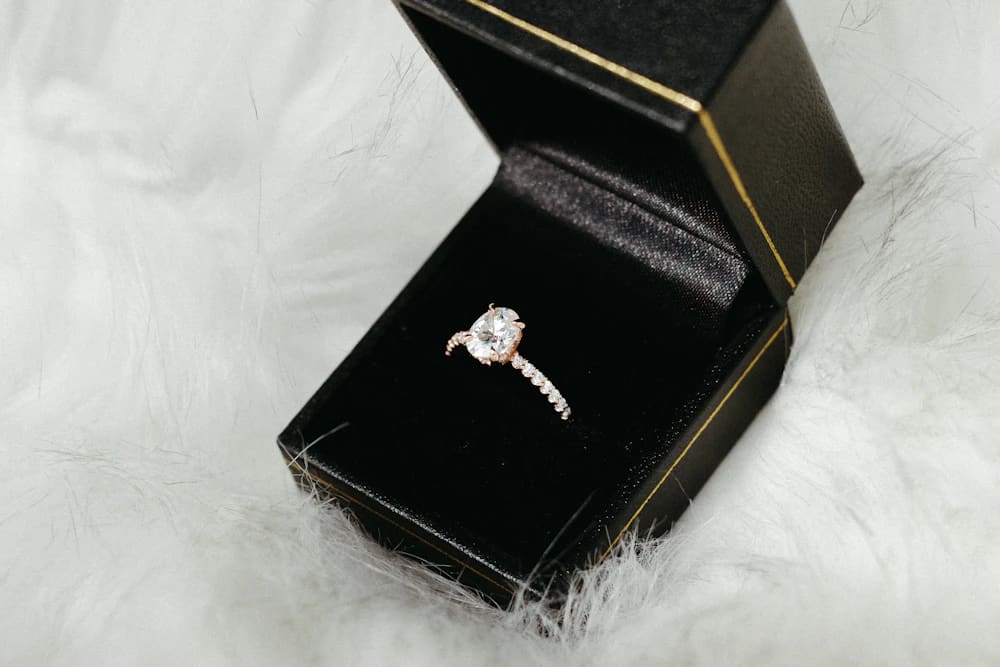 A diamond solitaire ring in a black presentation box