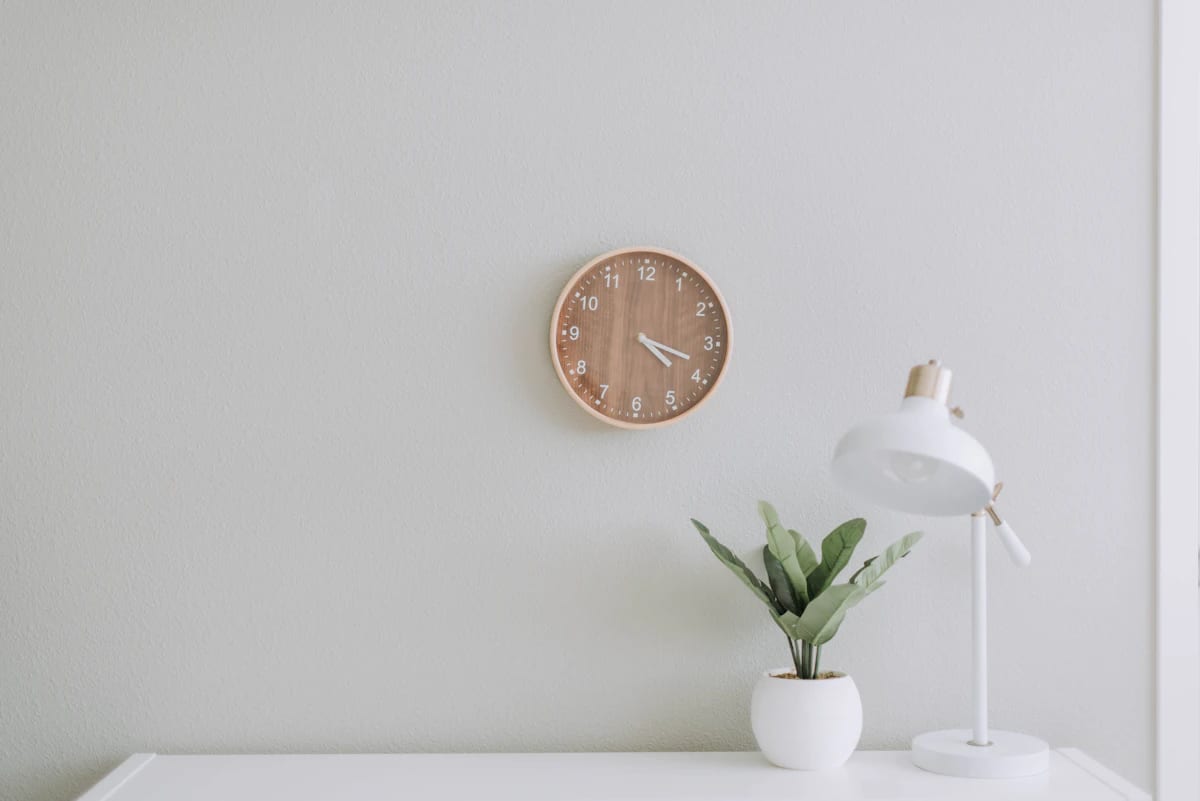 Round oak wall clock on a white wall